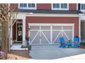 Exterior view of the garage with a light gray door and two chairs in front of the driveway at 1992 Kings Gate Ln, Mount Pleasant, SC 29466