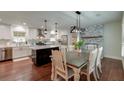 Bright dining area with modern lighting, stone fireplace, and an open concept kitchen at 203 Red Fox Run, Summerville, SC 29485
