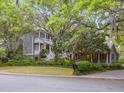 Beautiful two-story home with double porches surrounded by lush greenery, showcasing Southern charm at 2206 Weepoolow Trl, Charleston, SC 29407