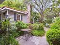 Cozy brick patio with a table and chair set, surrounded by lush gardens and a charming white fence at 2206 Weepoolow Trl, Charleston, SC 29407