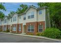 Charming townhomes with brick and siding exteriors, surrounded by lush trees and landscaping at 241 Howle Ave # H, Charleston, SC 29412