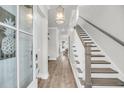 Bright foyer featuring hardwood floors, stairs, and a stylish light fixture at 2729 Battery Pringle Dr, Johns Island, SC 29455