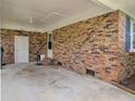 Spacious brick carport with white door, exposed brick wall and concrete flooring at 296 Oxford Rd, Ladson, SC 29456