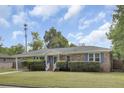 Well-maintained brick home with lush lawn, classic shutters and covered parking on a sunny day at 296 Oxford Rd, Ladson, SC 29456