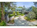 Stately home featuring a circular driveway, elegant fountain, and lush landscaping at 2970 Roseville Rd, Wadmalaw Island, SC 29487