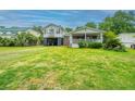 Charming two-story home featuring a large yard, an open carport, and a cozy porch in a picturesque neighborhood at 312 Lake Moultrie Dr, Bonneau, SC 29431