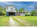 Charming elevated home featuring a large yard, an open carport, and a cozy porch, offering a blend of comfort and practicality at 312 Lake Moultrie Dr, Bonneau, SC 29431