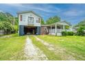 This charming raised house offers an open carport and a welcoming porch, ideal for relaxation and outdoor enjoyment at 312 Lake Moultrie Dr, Bonneau, SC 29431