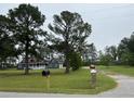 Well-kept exterior featuring a gray home with a cozy front porch and shed with well-maintained lawn at 341 Sugar Hill Rd, Saint George, SC 29477