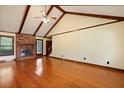Spacious living room with vaulted ceilings, wood beams, a brick fireplace, and hardwood flooring at 415 Whitebark Dr, Ladson, SC 29456