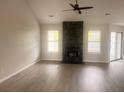 Bright living room featuring a stone fireplace, wood-look floors, and ample natural light at 4414 Rice Mill Dr, North Charleston, SC 29420