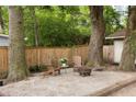 Relaxing backyard with Adirondack chairs, a fire pit, mature trees, and a privacy fence at 5037 Alpha St, North Charleston, SC 29405
