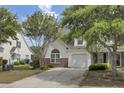 Charming two-story home with a one car garage, well-maintained landscaping and a paved driveway on a sunny day at 5223 Fernland Way, Charleston, SC 29420