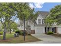 Charming two-story home with a one car garage, well-maintained landscaping and a paved driveway on a sunny day at 5223 Fernland Way, Charleston, SC 29420