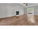 Bright living room features wood floors, a ceiling fan, a fireplace, and a glass door to the patio at 543 Castle Hall Rd, Mount Pleasant, SC 29464