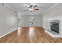 Open living room with fireplace, wood-look floors, ceiling fan, and a sunlit window at 543 Castle Hall Rd, Mount Pleasant, SC 29464