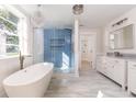 Spa-like bathroom featuring a freestanding tub, a glass-enclosed shower, and marble floors at 83 Avondale Ave, Charleston, SC 29407