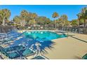 Refreshing community pool surrounded by lounge chairs and swaying palm trees at 9 Fairway Dunes Ln, Isle of Palms, SC 29451