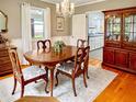 Cozy dining room with hardwood floors, chandelier, and seamless view into the kitchen at 104 Bryant St, Saint George, SC 29477