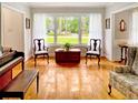 Inviting living room featuring hardwood floors, large windows, and charming vintage accents at 104 Bryant St, Saint George, SC 29477