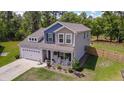 An aerial view showcases the home, highlighting the landscaped yard, two car garage, and inviting front porch at 107 Belgian Ct, Summerville, SC 29486