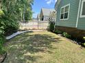 Backyard features a grass lawn, with gravel and landscaped garden beds, and a privacy fence at 1207 Rivers Reach Dr, Wando, SC 29492
