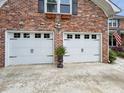 Spacious two-car garage with white doors and classic black iron hardware and a brick exterior at 16 Charlyn Dr, Charleston, SC 29407