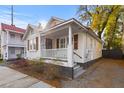 Charming home with a red roof, white siding, and a cozy front porch surrounded by landscaping at 177 Spring St, Charleston, SC 29403