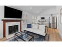 Open-concept living space featuring a fireplace, large television, and an adjacent modern kitchen at 177 Spring St, Charleston, SC 29403