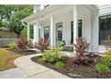 Charming front porch featuring classic columns, a cozy seating area, and beautifully landscaped surroundings enhancing curb appeal at 1872 Rifle Range Rd, Mount Pleasant, SC 29464