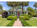 Inviting home with a red door, lush landscaping, and a charming water fountain feature at 2050 Wappoo Hall Rd, Charleston, SC 29412