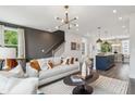 Open-concept living area leading to a modern kitchen with island seating and a staircase at 209 Somerset Acres Dr, Summerville, SC 29486