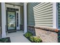 Inviting front porch with white columns and brick accents leading to a modern front door at 234 Basket Grass Ln, Summerville, SC 29486