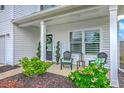 Inviting front porch with seating, decorative plants, and an elegant wreath on the front door at 306 Lucca Dr, Summerville, SC 29486