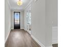 Well-lit entryway with hardwood floors, a black front door, and views through glass paneled french doors at 389 Wappoo Trace Ln, Summerville, SC 29486