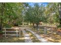 Scenic view of gated driveway leading to home surrounded by mature trees at 398 W Fisher Rd, Summerville, SC 29483