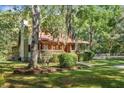 Charming log cabin with covered porch, landscaped yard, and mature trees at 398 W Fisher Rd, Summerville, SC 29483
