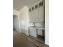 Bright eat-in kitchen features white cabinets, stainless sink, and stone countertops, perfect for meal preparation at 428 Evening Glow Ln, Summerville, SC 29486