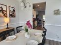 Well-lit dining room featuring a modern table setting and hardwood floors, leading to the kitchen at 435 Foxbank Plantation Blvd Blvd, Moncks Corner, SC 29461