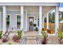 Inviting front porch features classic columns and a charming rocking chair, enhanced by beautiful landscaping at 435 Woodgate Way, Summerville, SC 29485