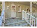 Inviting front porch with a view, features a sign, plants, and white railings at 4401 Prices Bridge Ln, Walterboro, SC 29488