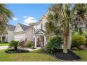 Attractive two-story home with lush landscaping, vibrant plants, and a welcoming front entrance, creating a warm curb appeal at 5258 Mulholland Dr, Summerville, SC 29485