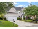 Inviting two-story home featuring an attached garage, a well-maintained lawn, and a charming entrance at 5258 Mulholland Dr, Summerville, SC 29485