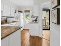 Bright kitchen features white cabinets, granite counters, and hardwood floors at 55 Fairway Dunes Ln, Isle of Palms, SC 29451