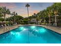 Resort-style community pool with lounge chairs surrounded by mature palm trees at 55 Fairway Dunes Ln, Isle of Palms, SC 29451