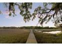 Picturesque marsh view with a long dock, gazebo, and boat lift under a stunning sky at 554 Parrot Point Dr, Charleston, SC 29412