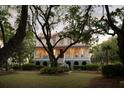 Charming two-story home with a red roof and a sprawling front yard at dusk at 554 Parrot Point Dr, Charleston, SC 29412