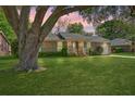 Charming brick home with lush green lawn, attached garage and mature trees in a neighborhood setting at 816 Farnham Rd, Charleston, SC 29412