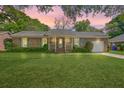 Charming brick home features a well-maintained lawn, attached garage, and a welcoming front porch at 816 Farnham Rd, Charleston, SC 29412