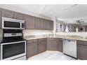 Well-lit kitchen features stainless steel appliances, ample gray cabinets, and speckled granite countertops at 8651 Grassy Oaks Trl, North Charleston, SC 29420